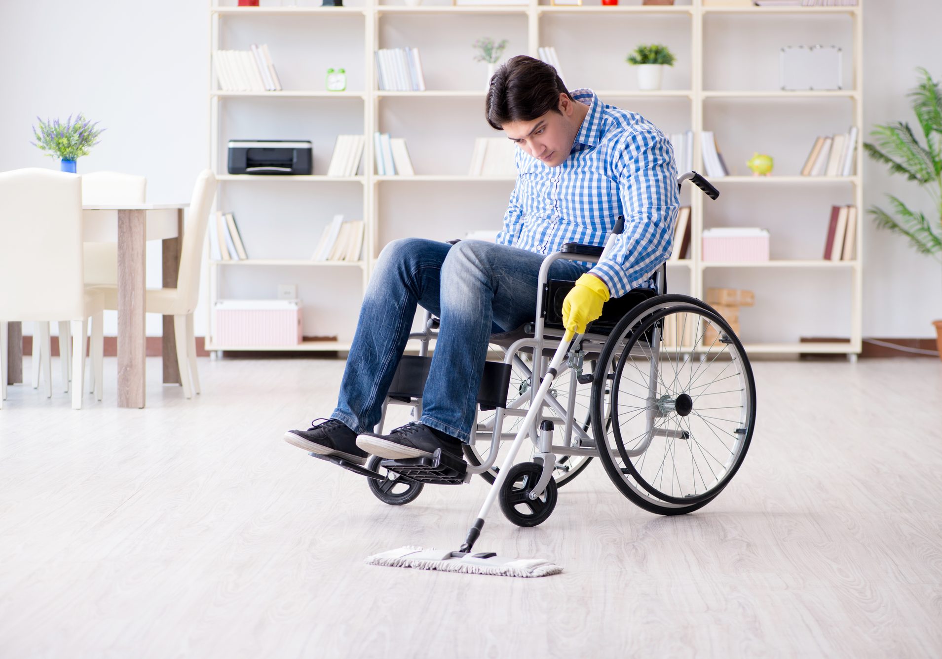 Disabled man on wheelchair cleaning home