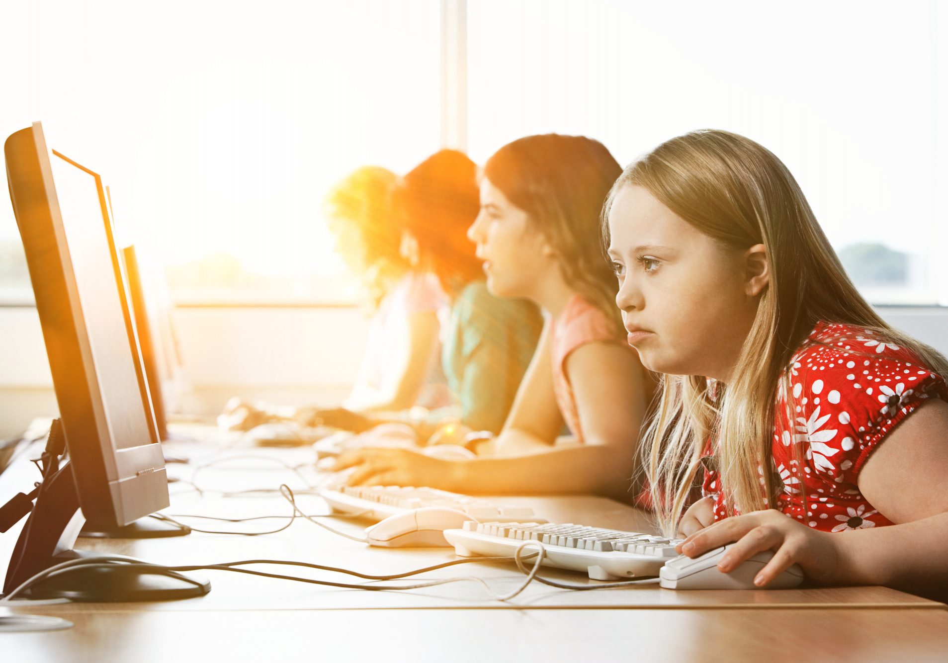 Girl with Down syndrome using computer at school